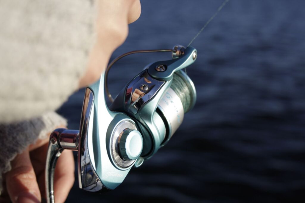 水辺でスピニングリールを手に持つ様子