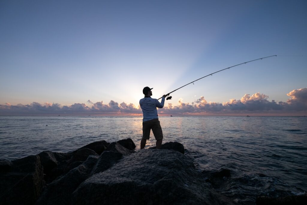夕方、海で釣りをする人